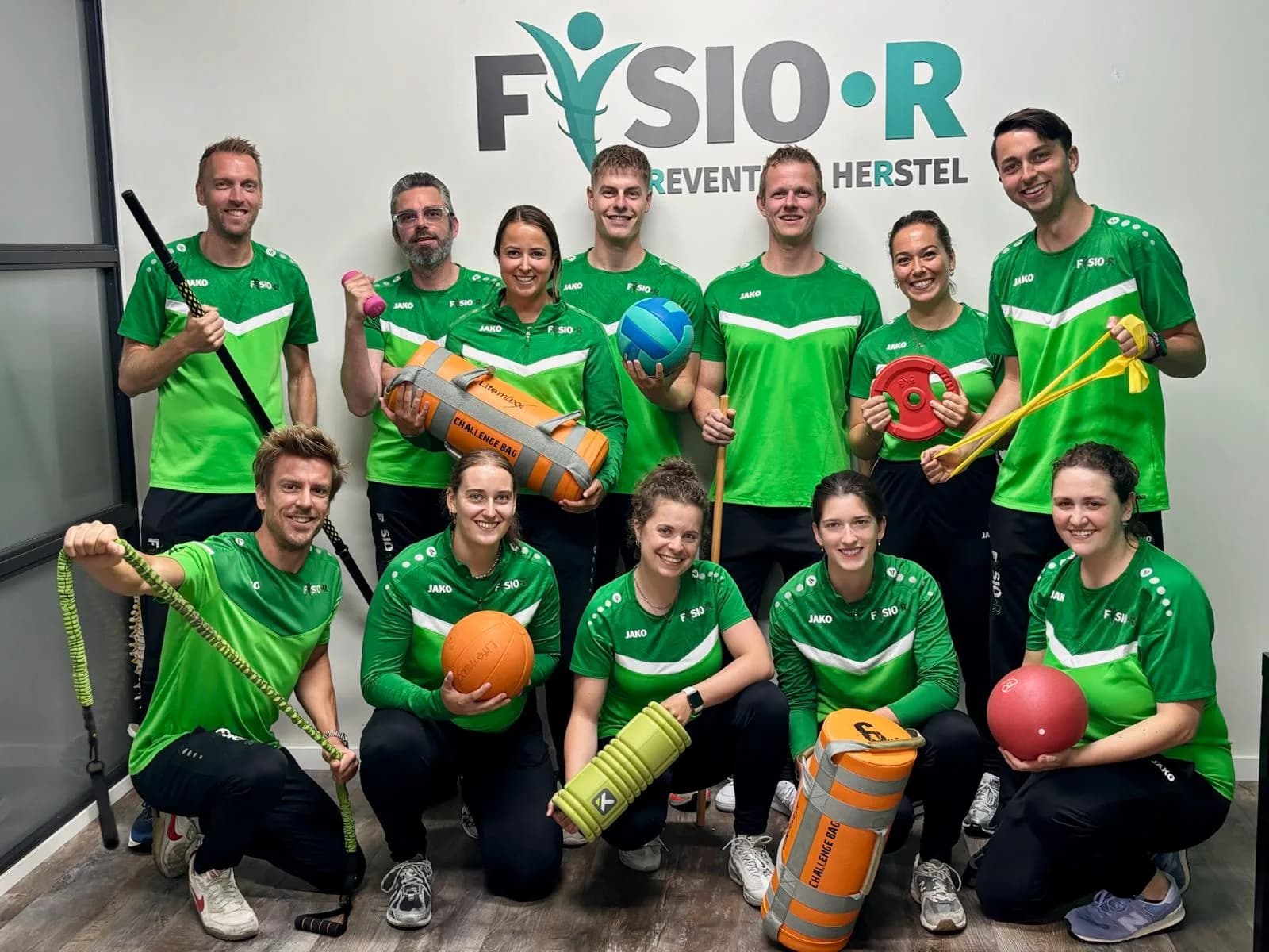 Het team van Fysio-R met trainingsmateriaal in de oefenzaal
